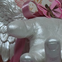 Abformung einer Kinderhand, wunderschöne Engelsflügel, beides jeweils Vollguss und in Perlmutt lackiert, auf einem Bilderrahmen mit Schmetterlingshintergrund, Federschmetterlinge sowie Satinband und kleiner Hortensienblüte.